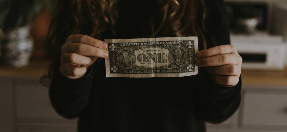 Person hält eine 1-Dollar-Note