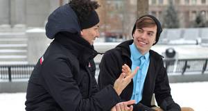 Zwei Männer unterhalten sich auf einer Bank in weißer Schneelandschaft