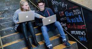 Zwei Studenten sitzen vor Laptop