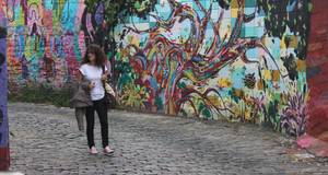 Frau vor buntbemalter Wand in Brasilien