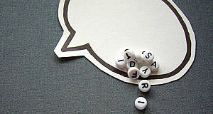 ausgedruckte Sprechblase mit kleinen Steinchen mit Buchstaben drauf
