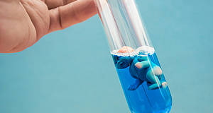 Baby in Reagenzglas schwimmend in blauer Flüssigkeit