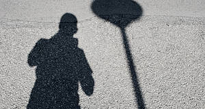 Schatten von Mann und Lampe auf der Straße