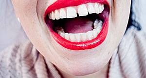 Nahaufnahme: offener Mund einer Frau mit rotem Lippenstift