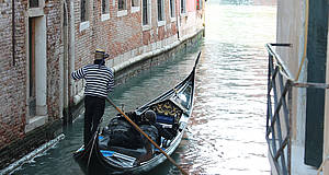 Venezianischer Mann treibt sein Boot mit Ruder an