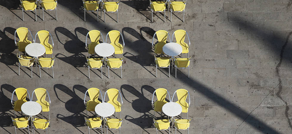 gelbe Stühle mit Tischen aufgereiht