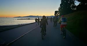 Radfahrer am Meer bei Sonnenuntergang