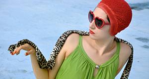 Frau mit Badehaube hält Leopardenschal auf der Hand