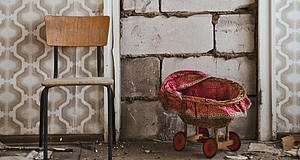 Stuhl und Kinderwagen im verlassenen Raum