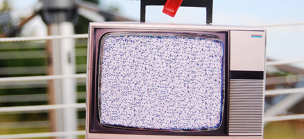 alter flimmender Fernseher hängt an Wäscheleine 