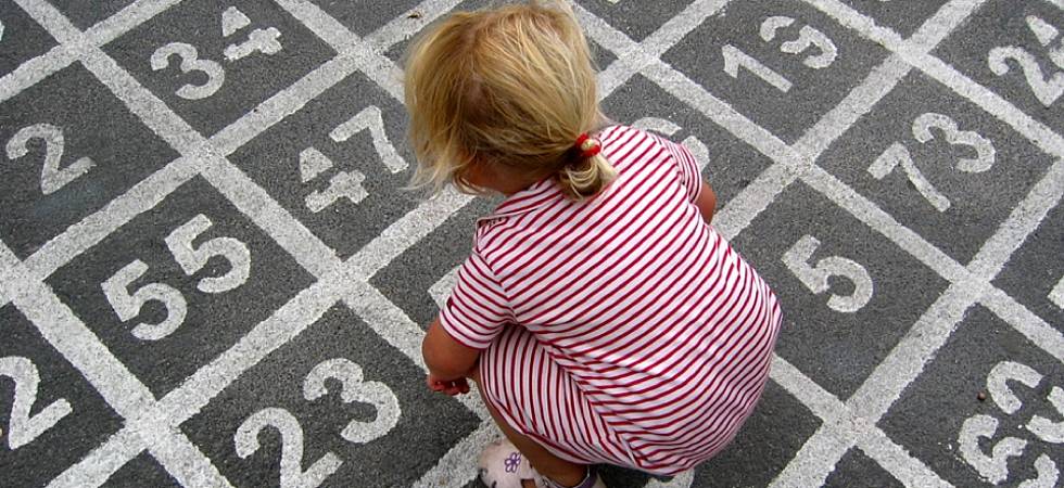 Kind sitzt auf großem Zahlenfeld