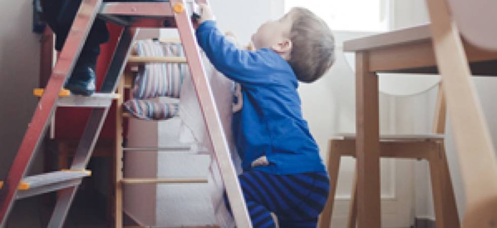 Kleinkind auf der Leiter im Wohnzimmer