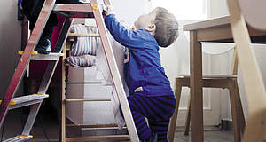 kleines Kind klettert auf Leiter