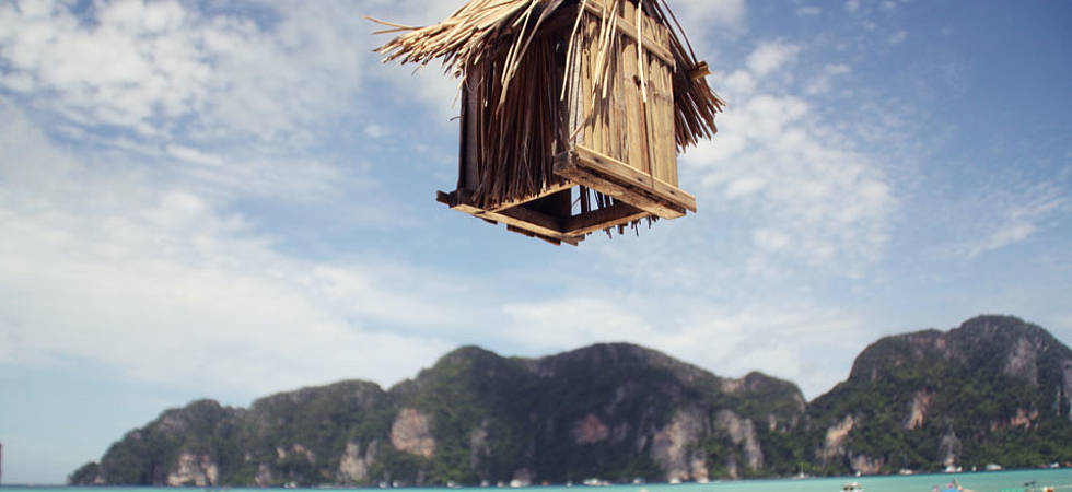 Holzhütte schwebt auf einer Insel in der Luft